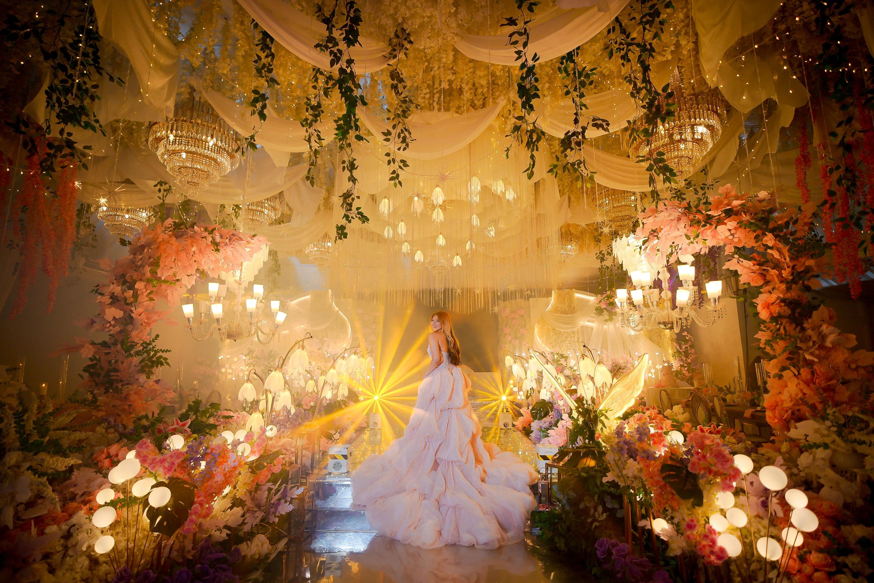 A portrait beneath golden lights and flowers, used as the upcoming film poster